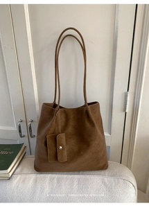 Detail of vintage matte brown tote bag with slim shoulder straps and small attached pouch