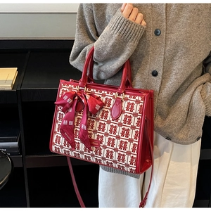 Detail of red jacquard wedding tote bag with traditional Double Happiness pattern and bow