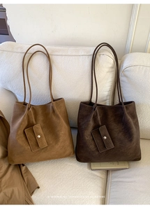 Close-up of minimalist large tote bags in brown and tan suede with matching mini pouches