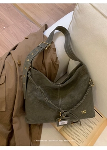 Detail of olive green leather bucket bag with braided shoulder strap and gold hardware
