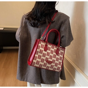 Detail showing the Chinese double joy pattern and red leather strap on the tote bag