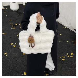 Détail du sac cabas blanc en fausse fourrure avec pendentif ours sur manteau noir