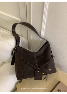 Detail of dark brown leather Hobo bag with white contrast stitching and gold metal ring