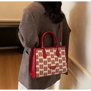 Detail of red and beige jacquard tote bag with traditional囍pattern on tweed coat