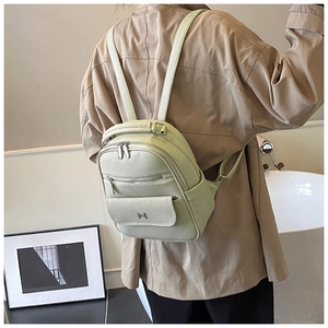 Detailed view of mint green backpack with lychee texture and metallic letter decor