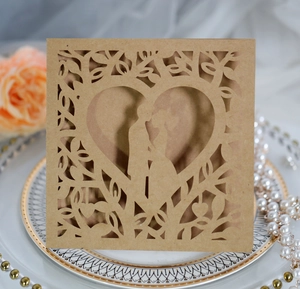 Detail of laser-cut heart tree design on cream wedding card with couple silhouette