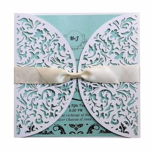 Laser cut wedding invitation with white floral cover and mint blue card with ivory ribbon
