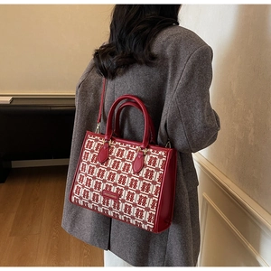 Detail of red wedding tote bag featuring double happiness patterns and leather straps