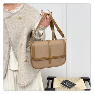 Detail of vintage rectangular crossbody bag featuring brown textile and leather accents
