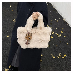 Gros plan d'un sac cabas en peluche douce avec un charmant pendentif ours mignon