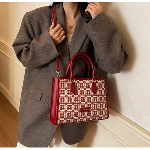 Detail of red wedding tote bag featuring festive double happiness jacquard and leather strap