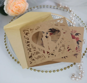 Detail of laser-cut heart and couple silhouette wedding invitation on cream paper