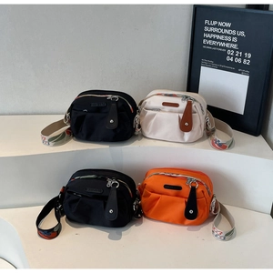 Detail of stylish nylon pleated crossbody bags with embroidered floral wide straps