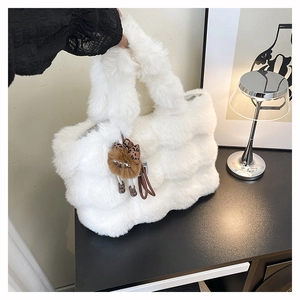 Détail du sac cabas en peluche blanche avec coutures ondulées et breloque singe marron