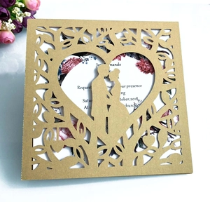 Detail of gold laser-cut wedding invitation featuring heart-shaped couple silhouette