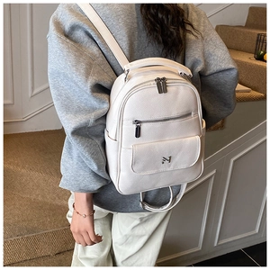Close-up of white lychee pattern leather backpack with silver metal N logo and multi-zipper