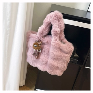 Détail de la texture d'un sac cabas rose en peluche avec un adorable pendentif ours