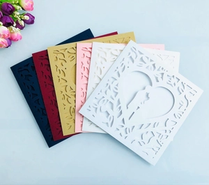 Détail de faire-part de mariage découpés au laser en cinq couleurs avec motif de cœur