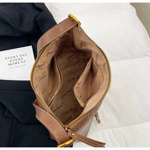 Detail view of brown leather bucket bag interior with spacious pockets and branded lining