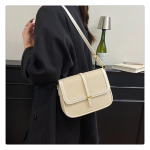 Detail view of cream crossbody bag featuring canvas texture and adjustable strap