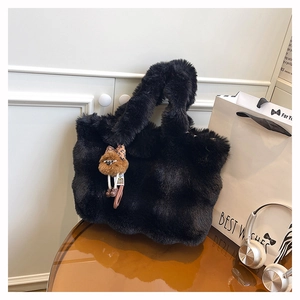 Détail du sac cabas en peluche noire avec un porte-clés ourson brun décoratif
