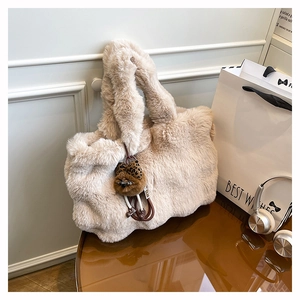 Vue détaillée du sac cabas beige en peluche avec breloque d'ours et texture douce