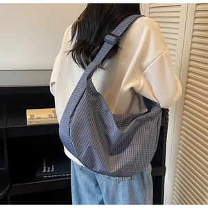 Dettaglio della borsa hobo a quadri grigi con tracolla regolabile in stile casual