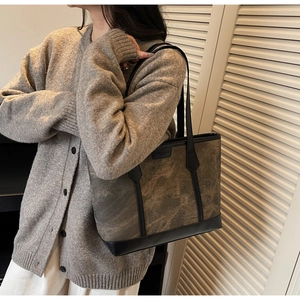 Seitenansicht der großen Shopper Tasche mit Marmormuster und schwarzen Lederakzenten