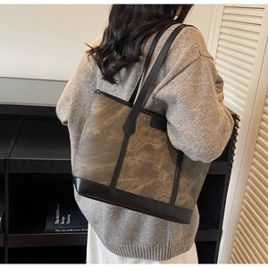 Modell mit großer Canvas-Tragetasche in Vintage-Grün mit schwarzen Lederriemen und Rand