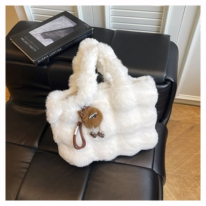 Détail du sac cabas en fausse fourrure blanche douce avec un charmant pendentif