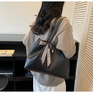 Close-up of black tote bag with geometric scarf detail and spacious interior design