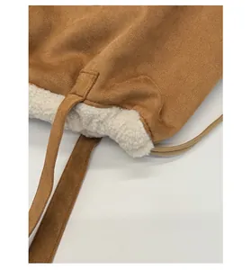 Detailed macro view of the brown suede and white faux fur texture on this tote bag