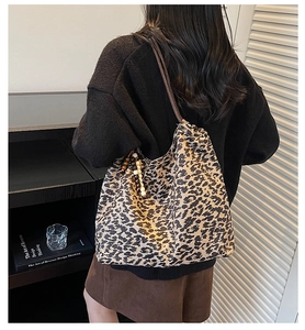 Détail du sac cabas en toile léopard avec pompon décoratif en perles de bois