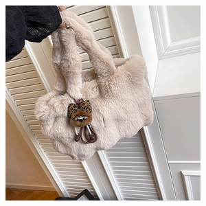 Détail du sac cabas en fausse fourrure crème douce avec un accessoire de breloque ours mignon