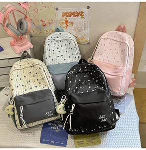 Detail showing high-capacity nylon school backpacks in four colors with star patterns