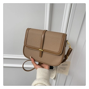 Detail of vintage brown canvas shoulder bag with leather trim and gold hardware