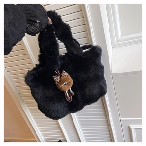 Détail d'un sac cabas en fausse fourrure noire avec nœud léopard et peluche douce