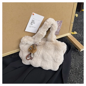 Détail du sac cabas en fausse fourrure beige avec un porte-clé ours en léopard