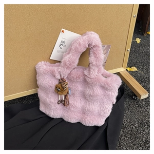 Détail du sac fourre-tout en fausse fourrure rose avec breloque cœur léopard et pompon