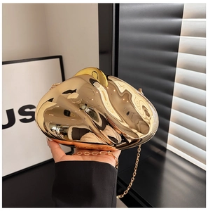 Close-up of golden metallic shell clutch with mirror finish and elegant gold chain strap