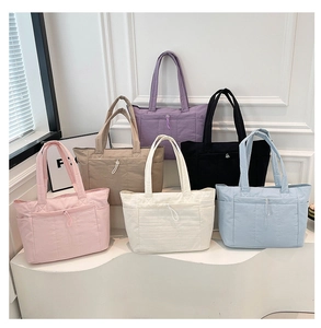 Détail de sacs cabas matelassés en nylon multicolores avec poche avant à cordon