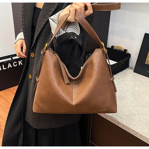 Brown leather tote bag featuring a spacious interior and retro gold metal hardware accents
