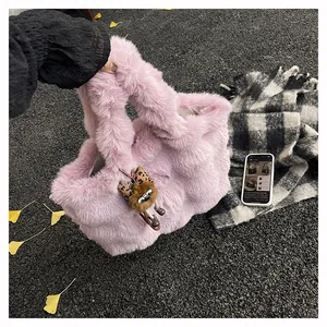 Détail d'un cabas en fausse fourrure rose avec pendentif peluche sur le sol