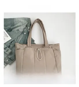 Détail du sac cabas matelassé kaki clair avec poches latérales et cordon de serrage