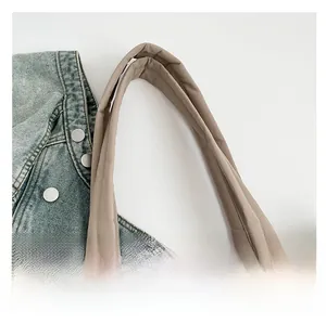 Détail des larges anses renforcées et coutures en X sur le sac fourre-tout matelassé
