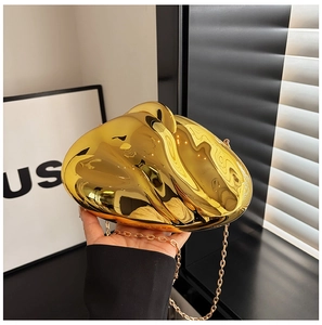 Detail of a gold irregular pebble-shaped acrylic evening bag with a metallic mirror finish