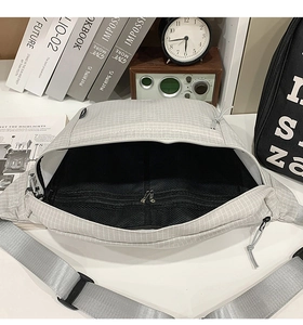 Détail du sac à bandoulière gris à carreaux avec fermeture éclair et poches en filet