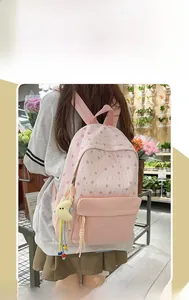 Detail of pink star pattern backpack with cute moon plush charm on a female model