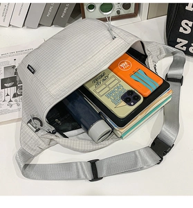 Vue détaillée de l'intérieur spacieux d'une sacoche en nylon gris clair avec objets divers