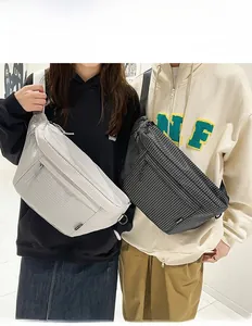 Détail de sacs bandoulière en nylon avec texture à carreaux en noir et gris